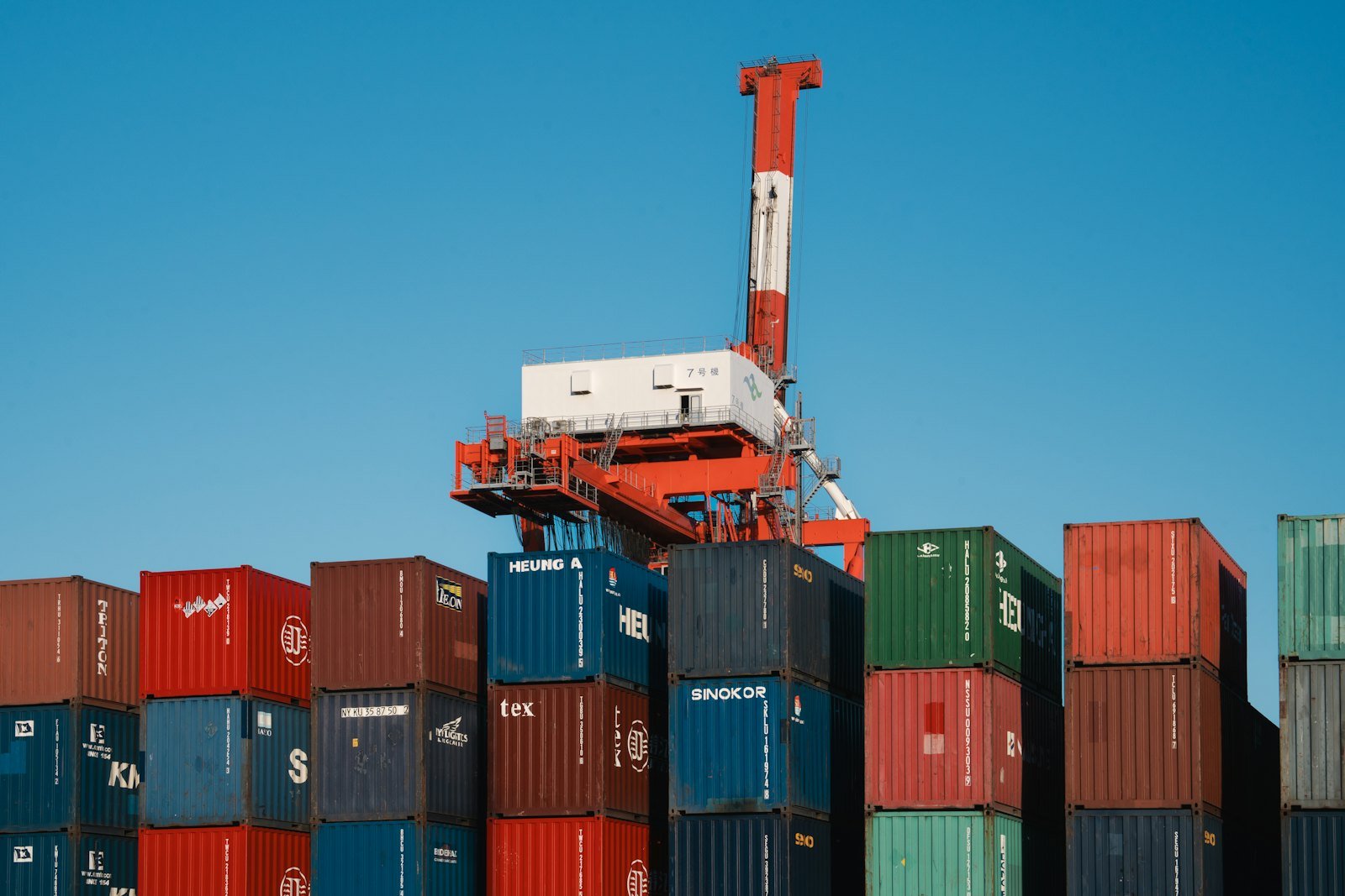 Stacked shipping containers under a port crane